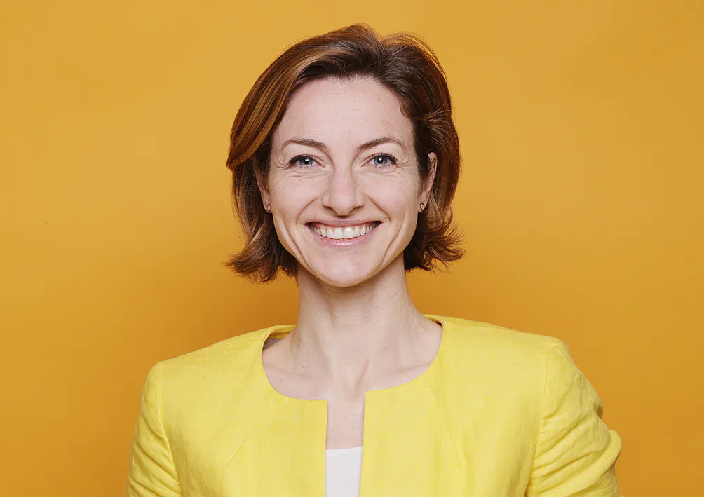 Karrierportrait Bewerbungsfoto lachende junge Frau in gelbem Outfit vor gelbem Hintergrund