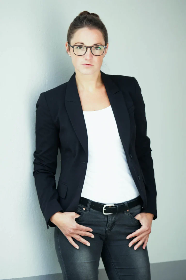 Bewerbungsfoto Profilbild junge Frau im Blazer mit weißem Shirt outdoor vor einer Wand